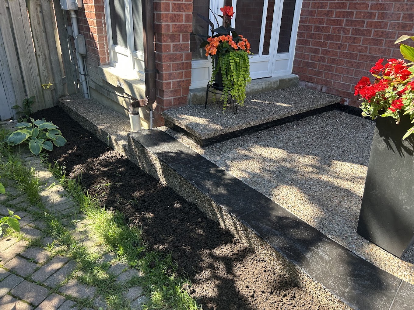 Aggregate front entry landing and step with black stamped concrete trim